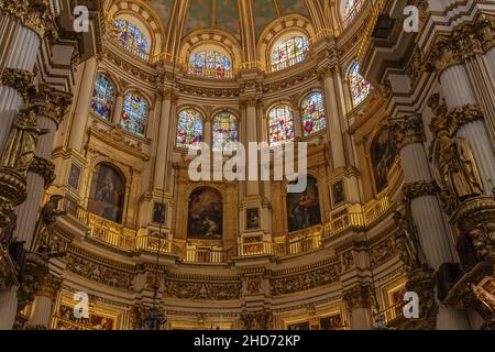 Il muro sotto la cupola della Cattedrale di Granada, riccamente decorata con dipinti. Sul muro sono scritti nomi di santi diversi. Foto Stock