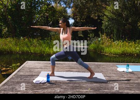 Tutta la durata della giovane donna in abbigliamento sportivo che pratica yoga nel parco Foto Stock