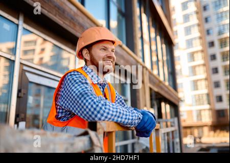 Ritratto di costruttore sorridente su culla appesa Foto Stock