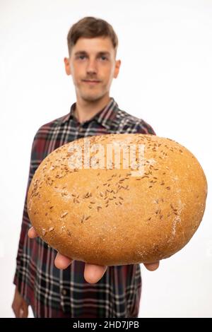Giovane bell'uomo bianco sottile con capelli marroni che ti offre pane in camicia di flanella isolato su sfondo bianco Foto Stock