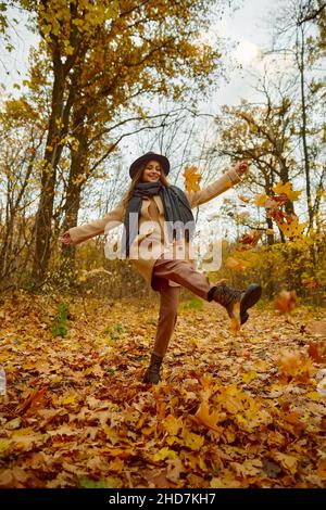Felice eccitata giovane donna sotto foglie caduta Foto Stock