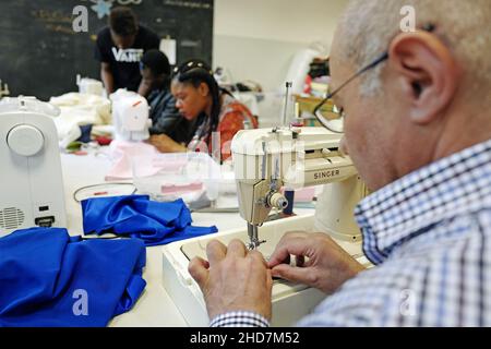 Rifugiati politici che lavorano su una sartoria dell'associazione no-profit linea Adele, a Milano. Foto Stock