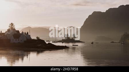 Alba sul porto di Plockton e Sgeir Bhuidhe sul Loch Carron a Lochalsh, Wester Ross, West Highlands Scozia Regno Unito - Scottish Coast Coastline paesaggap Foto Stock