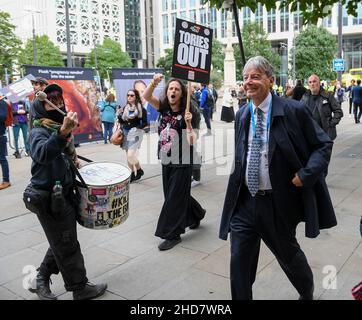 Un protester in un casco di polizia dimostra fuori dalla Conferenza dei conservatori 2021 a Manchester. Foto Stock