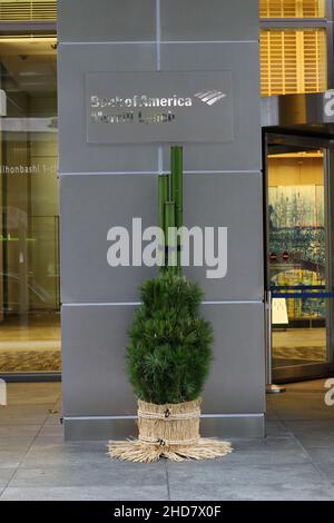 Ingresso all'edificio degli uffici Merrill Lynch Bank of America nell'area Nihonbashi di Tokyo con decorazioni Kadomatsu di fronte. Foto Stock