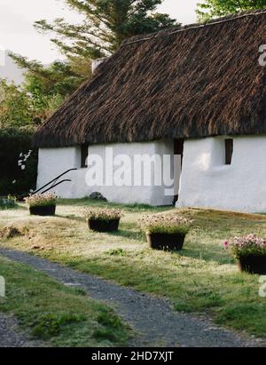 Un tradizionale cottage croft con tetto in paglia nel villaggio di Plockton sulle rive di Loch Carron a Lochalsh, Wester Ross, West Highlands Scozia UK Foto Stock