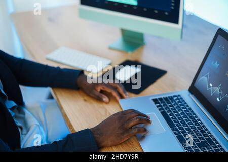 Trader africano che studia il mercato azionario in casa - Focus on right hand Foto Stock