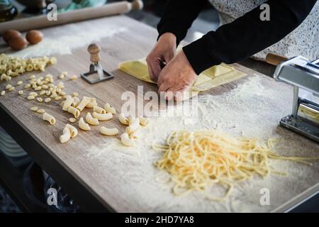 Donna prepara ravioli freschi all'interno della fabbrica di pasta Foto Stock