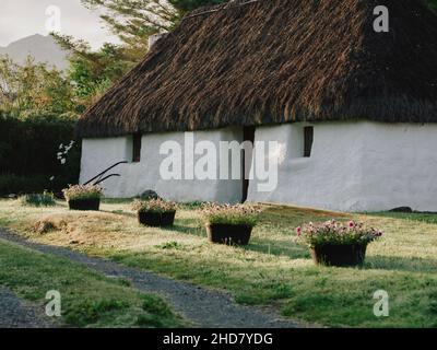 Un tradizionale cottage croft con tetto in paglia nel villaggio di Plockton sulle rive di Loch Carron a Lochalsh, Wester Ross, West Highlands Scozia UK Foto Stock