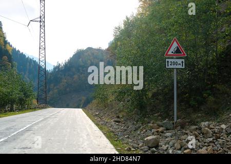 Cartello stradale Rockfall sulla strada lungo la serpentina in montagna copia spazio Foto Stock