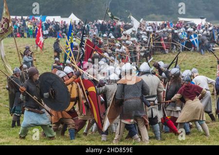 Inghilterra, East Sussex, Battle, The Annual Battle of Hastings 1066 Re-enactment Festival, partecipanti vestiti in Medieval Armor Fighting a Battle Foto Stock