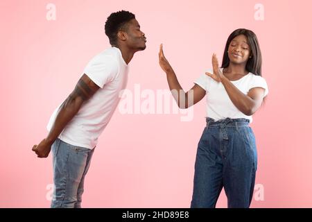 L'uomo che cerca di baciare la donna disgustata che lo respinge Foto Stock