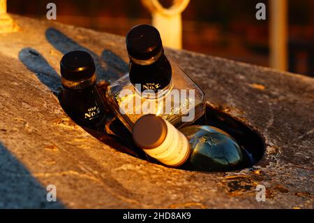 Un contenitore di vetro di scarto riempito in eccesso la sera. Foto Stock