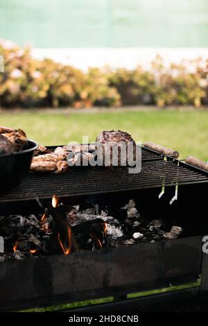 Cottura di carne e verdure su una griglia Foto Stock