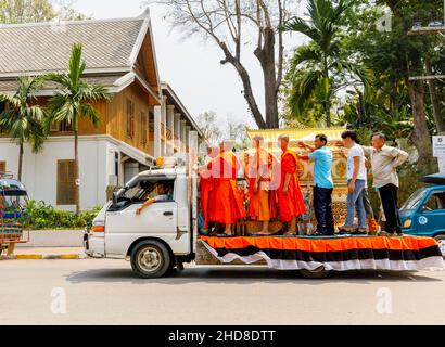 Scena stradale a Luang Prabang, Laos settentrionale, Asia sud-orientale: I tradizionali monaci buddisti zafferano con la zafferano si trovano sul retro di un furgone Foto Stock