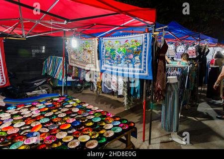 Appendiabiti decorativi e ciotole in mostra in una stalla nel mercato notturno della strada pedonale nel centro di Luang Prabang, Laos settentrionale, Asia sud-orientale Foto Stock