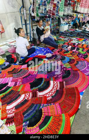 Colorate gonne di stile locale e tessuti esposti nel mercato notturno della strada pedonale nel centro di Luang Prabang, nel Laos settentrionale, nel sud-est asiatico Foto Stock