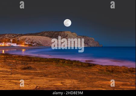 Luna piena sulla costa rocciosa di Praia da Luz, Algarve, Portogallo, Europa Foto Stock