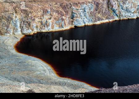 L'acqua nella fossa della miniera di Sao Domingos è rossa a causa del ferro ed è acida dall'ossidazione dello zolfo. Corte do Pinto, Alentejo, Portogallo. Foto Stock