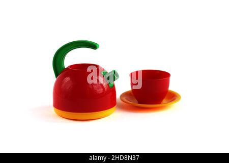 Vasellame giocattolo per bambini di colore chiaro - teiera, tazza e piatto isolato su bianco Foto Stock