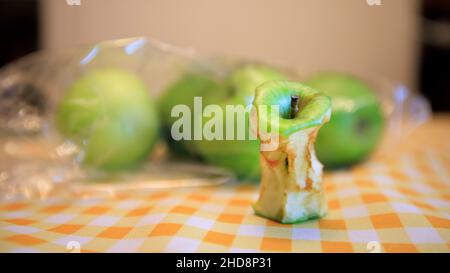 Un nocciolo di mela marcio accanto ad alcune mele fresche Foto Stock