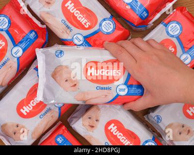 Tambov, Federazione russa - 21 dicembre 2021 Donna mano prendendo una Huggies wet wipe pack da heap Foto Stock