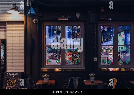 Londra, Regno Unito - 23 novembre 2021: Buon segno di Natale sulla finestra del pub o'Neills a Soho, un'area di Londra con un sacco di caffè e ristoranti. Foto Stock
