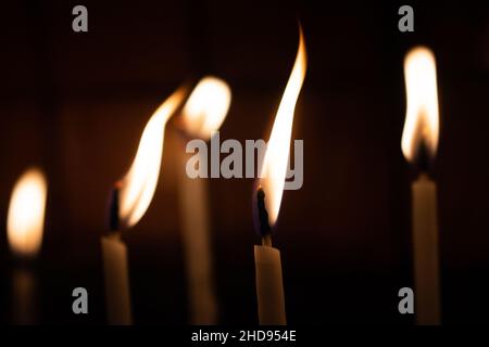 La candela si illumina nel buio. Sfondo candele astratto. Speranza, fuoco. Foto Stock