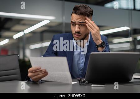 Perplesso il direttore medio-orientale che legge il rapporto finanziario, spazio di copia Foto Stock