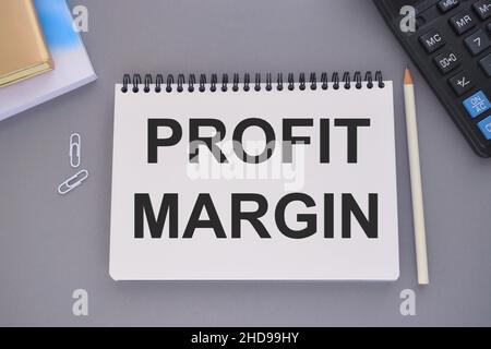 Scrittura manuale testo scrittura margine di profitto. Concetto che significa importo con cui i ricavi dalle vendite eccedono i costi in un'azienda maschio uomo lavoro formale sui Foto Stock