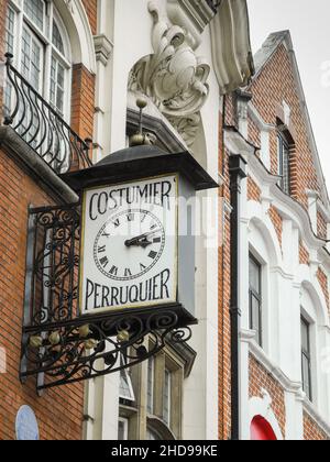 Orologio antico e ornato Costumier Perruquier sopra il ristorante Wong Kei su Wardour Street, Soho, Inghilterra, Regno Unito Foto Stock