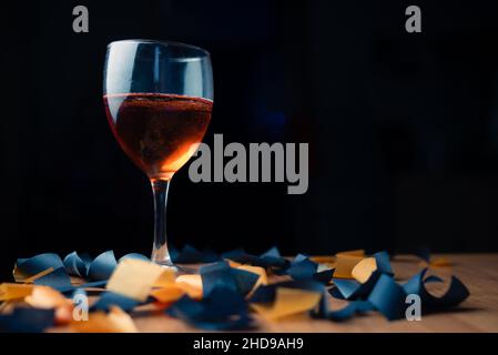 bicchiere di vino frizzante rosso su sfondo nero con caramelle Foto Stock