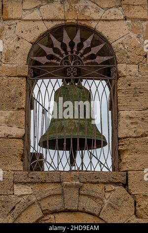 antico campanile in ottone o bronzo ospitato in un campanile in pietra sull'isola greca di zante o zante in grecia Foto Stock