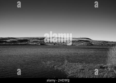 Scala di grigi di un bacino di Delph che guarda attraverso la stazione di trasmissione di Winter Hill TV nel Lancashire Foto Stock