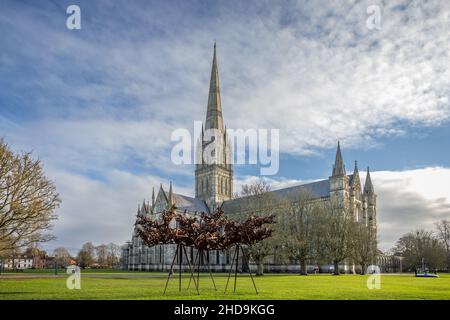 Cattedrale di Salisbury in stile gotico presa a Salisbury, Wiltshire, Regno Unito con scultura in acciaio intemperie in primo piano il 4 gennaio 2022 Foto Stock