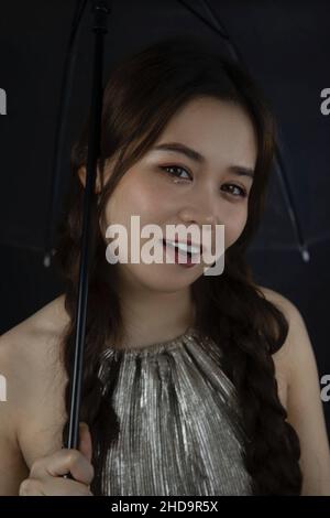 Ritratto di una bella ragazza sorridente dal Vietnam con un ombrello Foto Stock