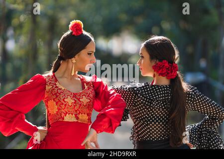 Due donne in flamenco tradizionale costume danzare fianco a fianco all'aperto Foto Stock