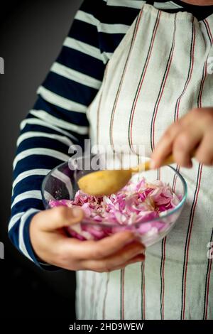 Donna che fa Pink Rose petalo Jam in cucina Foto Stock