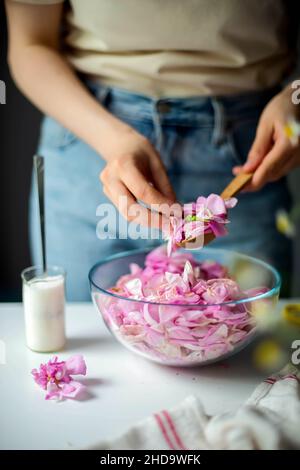 Donna che fa Pink Rose petalo Jam in cucina Foto Stock