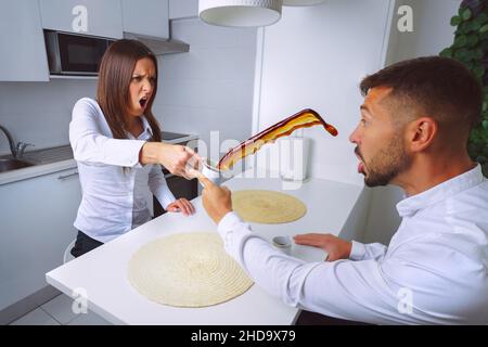 Giovane coppia litigando. Problemi di relazione. La donna arrabbiata lancia il caffè in mans Face. Foto Stock
