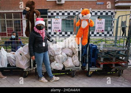 Madrid, Spagna. 04th Jan 2022. Un volontario della Fundacion Madrina visto accanto ai doni dei bambini alla vigilia di Epifania, nella Plaza de San Amaro. La consegna di doni e dolci da parte dei tre Re è rivolta ai bambini di famiglie vulnerabili vittime delle "code della fame". Lo scopo della manifestazione della Fondazione è di rendere omaggio ai bambini durante le vacanze natalizie che soffrono di drammi sociali delle loro famiglie a causa della situazione sanitaria. Il percorso continuerà a consegnare regali ai bambini da Pueblos Madrina. Credit: SOPA Images Limited/Alamy Live News Foto Stock