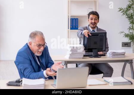 Due dipendenti di sesso maschile che lavorano in ufficio Foto Stock