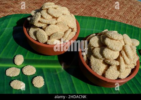 Gattino di zucchero di semi di Rewri o Sesamo, alimento ittico indiano di Sankranti. Rewri gajak servito in terrena ciotola su foglia di banana Foto Stock