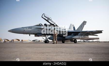 Un US Marine F/A-18 Hornet siede sulla linea di volo alla base aerea del Principe Sultano, Regno dell'Arabia Saudita, 23 dicembre 2021. L'arrivo del Marine Fighter Attack Squadron 115 migliora la capacità del Combined Forces Air Component Commander di muovere le forze fluidamente attraverso il teatro. (STATI UNITI Air Force foto di Senior Airman Jacob B. Wrightsman) Foto Stock