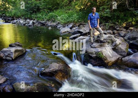 Un uomo attento siede nella Gola di Wutach nella Foresta Nera Foto Stock