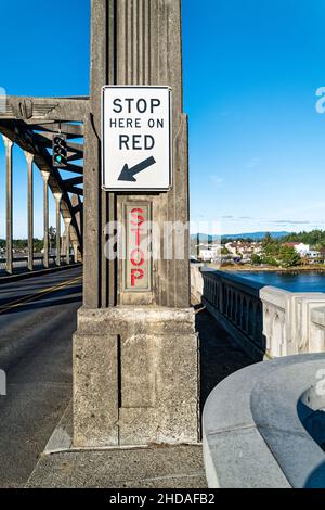 Segnale di stop illuminato in direzione nord del ponte sul fiume Siuslaw, Firenze, Oregon, USA Foto Stock