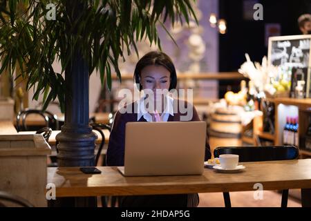 Lavoro a distanza. Donna africana americana concentrata freelancer utilizzando il laptop di lavoro in remoto in caffè Foto Stock