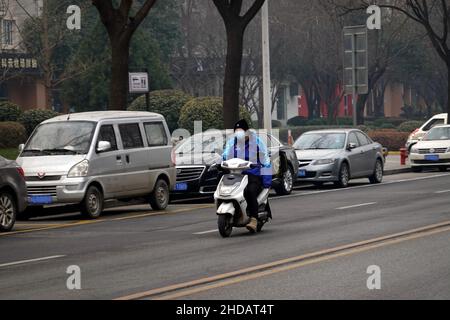 XI'AN, CINA - 5 GENNAIO 2022 - corriere e personale di pulizia in una strada a Xi'an, provincia di Shaanxi, Cina, 5 gennaio 2022. Foto Stock