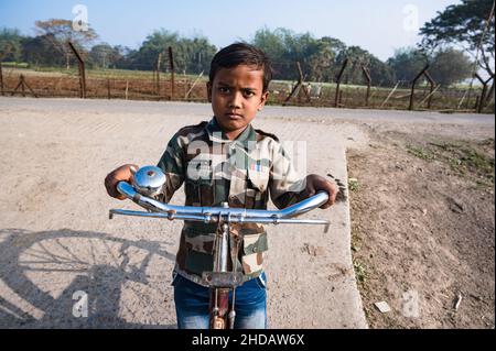 Tehatta, India. 04th Jan 2022. La vita degli abitanti del villaggio è accanto al confine India-Bangladesh nel pomeriggio a Nabin Nagar, West Bengala; India il 04/01/2022. Il coronavirus ha diffuso i suoi tentacoli in villaggi in tutta l'India, svelando uno dei problemi più temuti dell'India di affrontare la pandemia con un'infrastruttura sanitaria fragile e la mancanza di informazioni nelle zone rurali del paese. Questo ragazzino si sta girovagando indossando una divisa BSF (Indian Border Security Force). (Foto di Soumyabrata Roy/Pacific Press) Credit: Pacific Press Media Production Corp./Alamy Live News Foto Stock