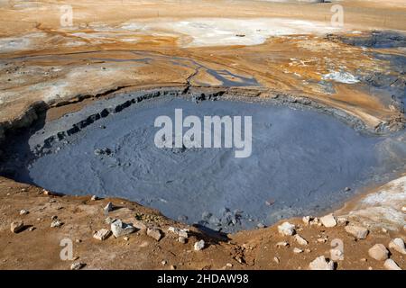 HVERIR, ISLANDA. Fango bollente e fumarole fumanti da una sorgente geotermica a Hverir vicino a Myvatn. Namafjall montagna sullo sfondo. Foto Stock